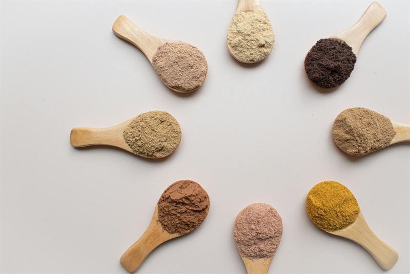 Wooden spoons filled with different ingredient powders